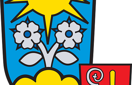 Wappen mit gelber Sonne, zwei weißen Blumen auf blauem Grund und kleinem roten Schild mit silbernem Bischofsstab und gelbem Symbol